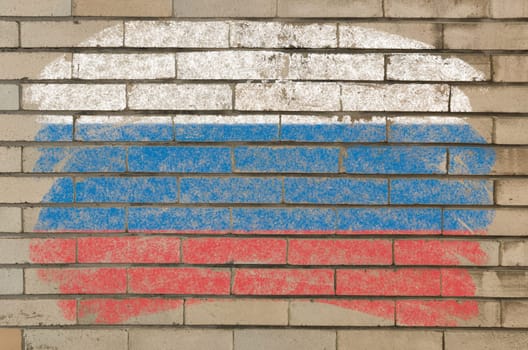Chalky russian flag painted with color chalk on grunge old brick wall