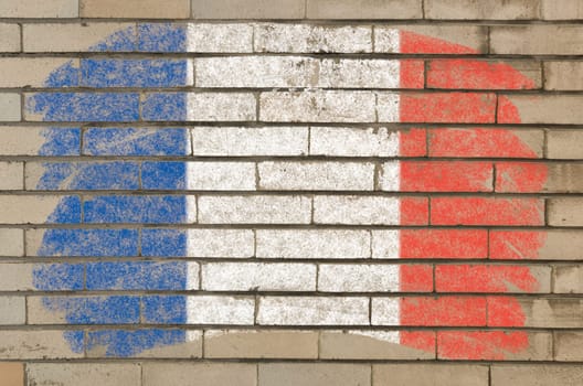 Chalky french flag painted with color chalk on grunge old brick wall