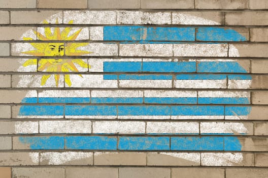 Chalky uruguay flag painted with color chalk on grunge old brick wall