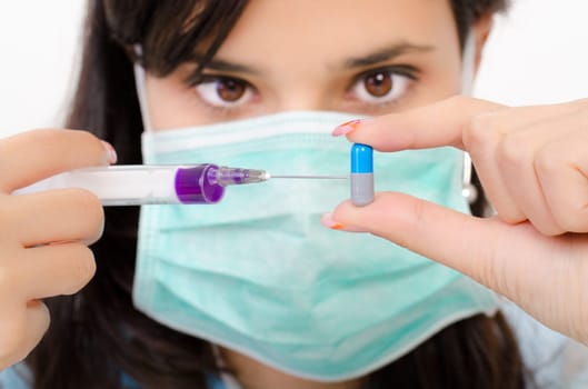 An attractive pharmacist woman inject a liquid in a pill