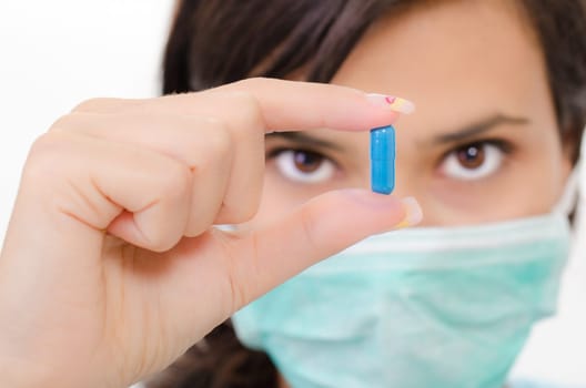 Blue pill in a woman&#039 s hand, isolated an a white background