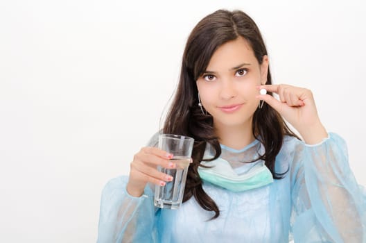 An attractive pharmacist is holding a pill and a glass of water
