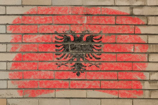 Chalky albanian flag painted with color chalk on grunge old brick wall