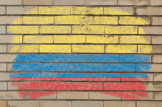 Chalky columbian flag painted with color chalk on grunge old brick wall