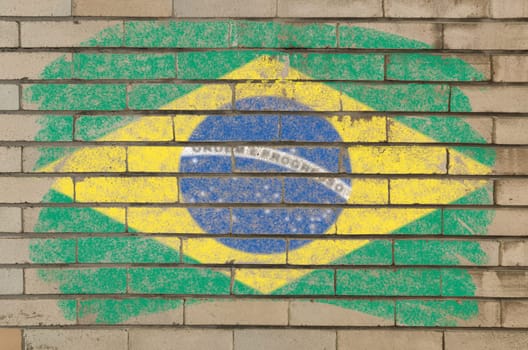 Chalky brazilian flag painted with color chalk on grunge old brick wall