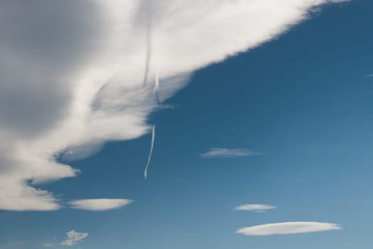 shadow of a cloud with the wake of a plane