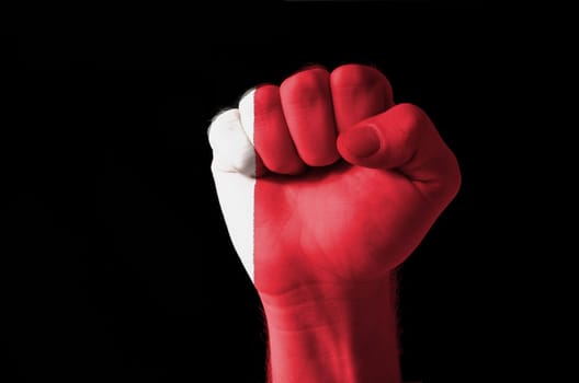 Low key picture of a fist painted in colors of bahrain flag