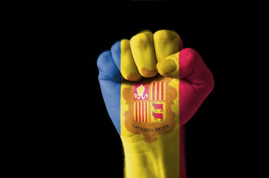 Low key picture of a fist painted in colors of andora flag