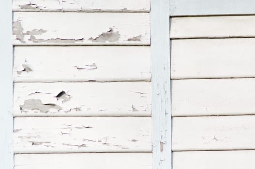 wooden wall with peeling white paint.