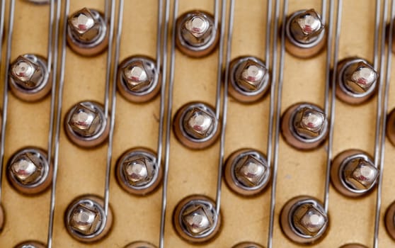 Close up image of interior of grand piano showing strings and structure