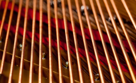 Close up image of interior of grand piano showing strings and structure