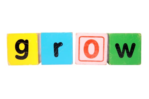 assorted childrens toy letter building blocks against a white background that spell grow with clipping path