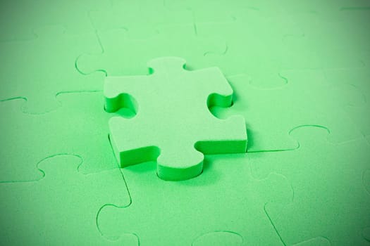 green puzzle with one piece pulled out