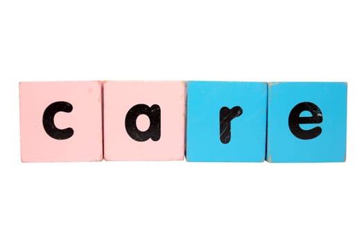 assorted childrens toy letter building blocks against a white background that spell care with clipping path