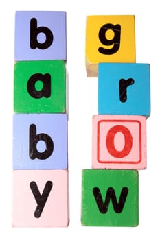 assorted childrens toy letter building blocks against a white background that spell baby grow with clipping path