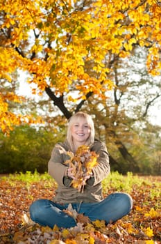 Teenager playing with autumn leaves