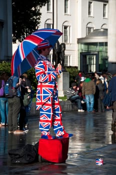 Human statue dressed in the Union Jack flag, London, UK