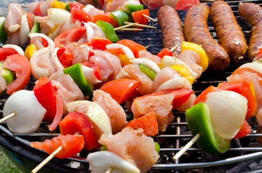Skewers with meats and vegetables cooking on the grill