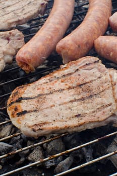 Sausages and pork cooking on the grill