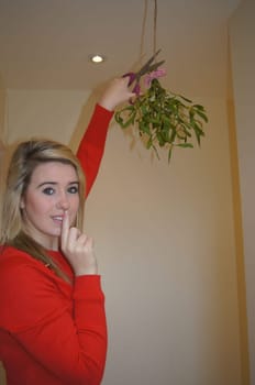 Girl secretly cutting down the mistletoe