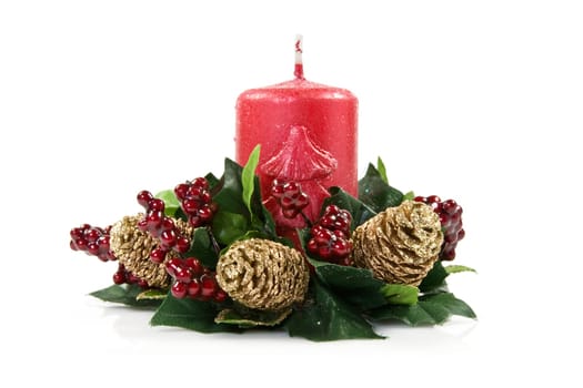 red  christmas candle,green plant with berries and cones