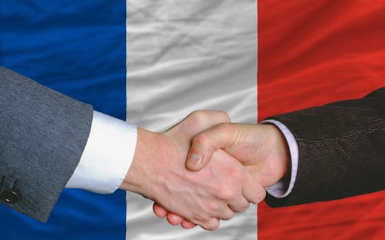 two businessmen shaking hands after good business investment  agreement in iceland, in front of flag