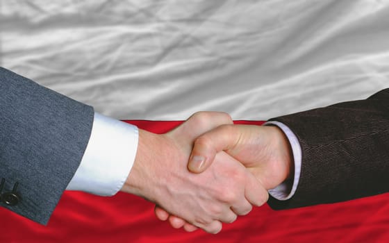 two businessmen shaking hands after good business investment  agreement in portugal, in front of flag