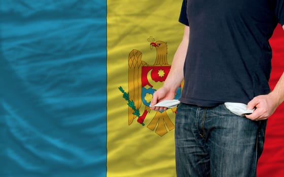 poor man showing empty pockets in front of moldova flag