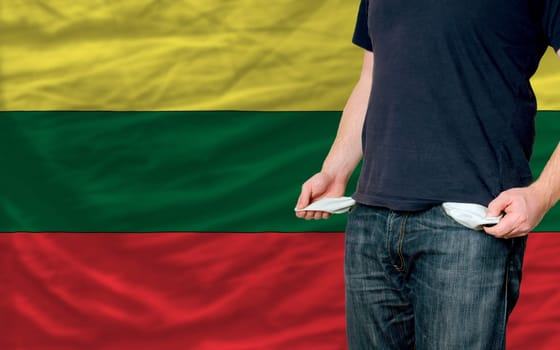 poor man showing empty pockets in front of lithuania flag