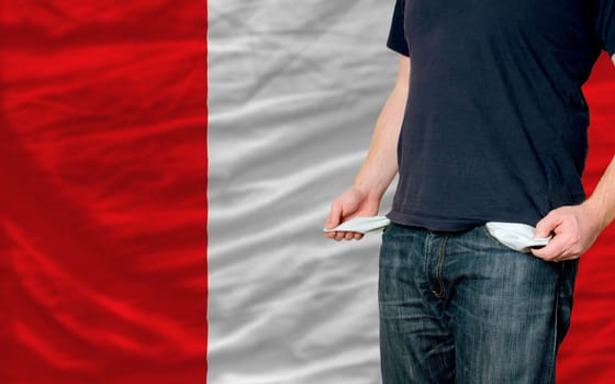 poor man showing empty pockets in front of peru flag
