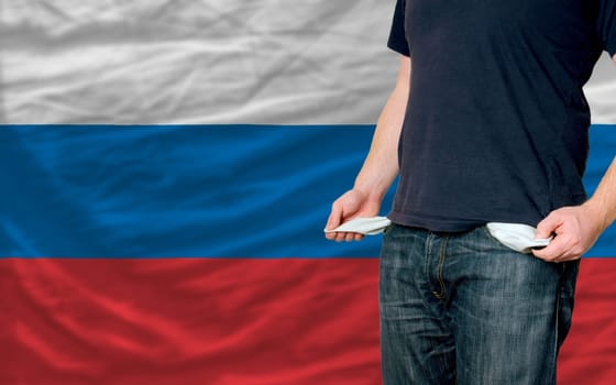 poor man showing empty pockets in front of russia flag