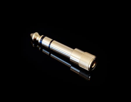 Adapter that converts one eighth inch to one quarter inch jack plugs used on headphones and microphones