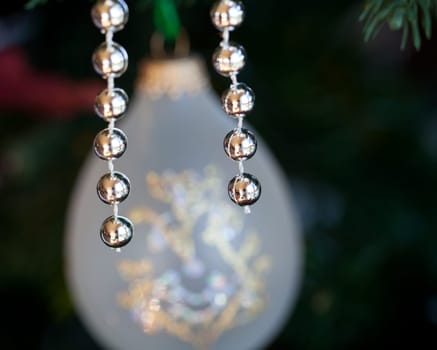 Christmas tree decorated with silver and white ribbons and ornaments in family home