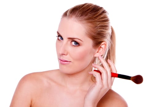 A head shot of a beautiful blond woman applying makeup.