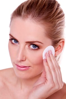 A head shot of a beautiful blond woman removing makeup.