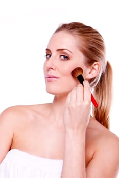 A head shot of a beautiful blond woman applying makeup.