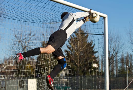 Soccer football goalkeeper making diving save