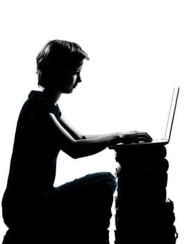 one caucasian young teenager silhouette boy or girl sitting computer computing laptop books full length in studio cut out isolated on white background