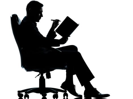 one caucasian business man sitting in armchair silhouette Full length in studio isolated on white background
