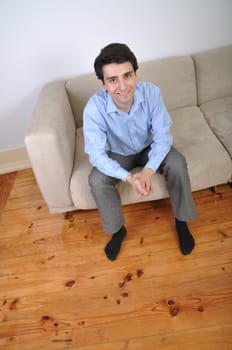 smiling attractive young man sitting on the couch