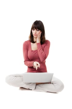 Beautiful woman pointing at the screen, with a laptop in studio with white background