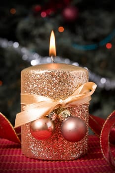 burning gold festive  candle  on xmas tree background