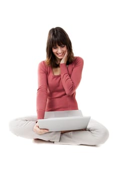 Beautiful woman with a laptop in studio with white background. Smiling and looking at the screen.