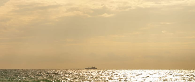 passenger ship at the horizon against a beautiful sunset