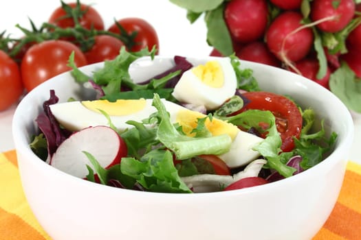 a white bowl of mixed salad