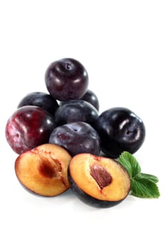 Fresh blue plums against white background