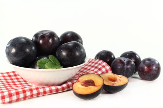 Fresh blue plums against white background