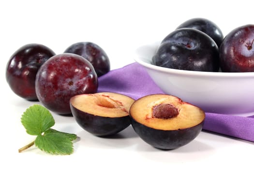Fresh blue plums against white background
