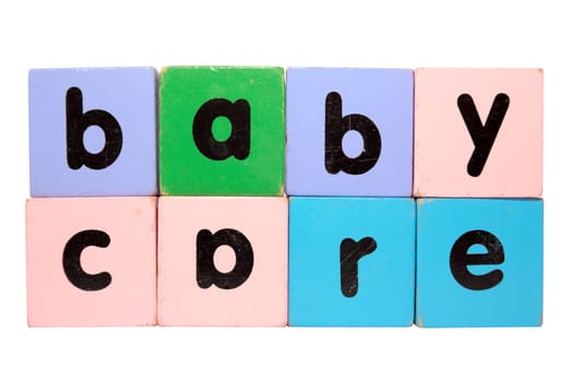 assorted childrens toy letter building blocks against a white background that spell baby care with clipping path