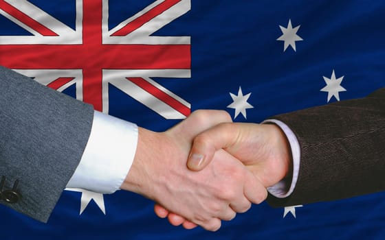 businessmen handshake after good deal in front of australia flag